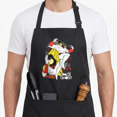 Space superhero apron - Two overlapping Space Ghost cartoon figures with printed text in white, yellow, red, and black — shown on a black cotton canvas apron against a white background