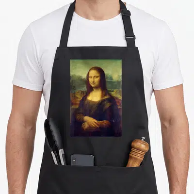 Leonardo mona lisa apron - Portrait of a woman in dark clothing against a landscape background in brown and green tones — shown on a black cotton canvas apron against a white background