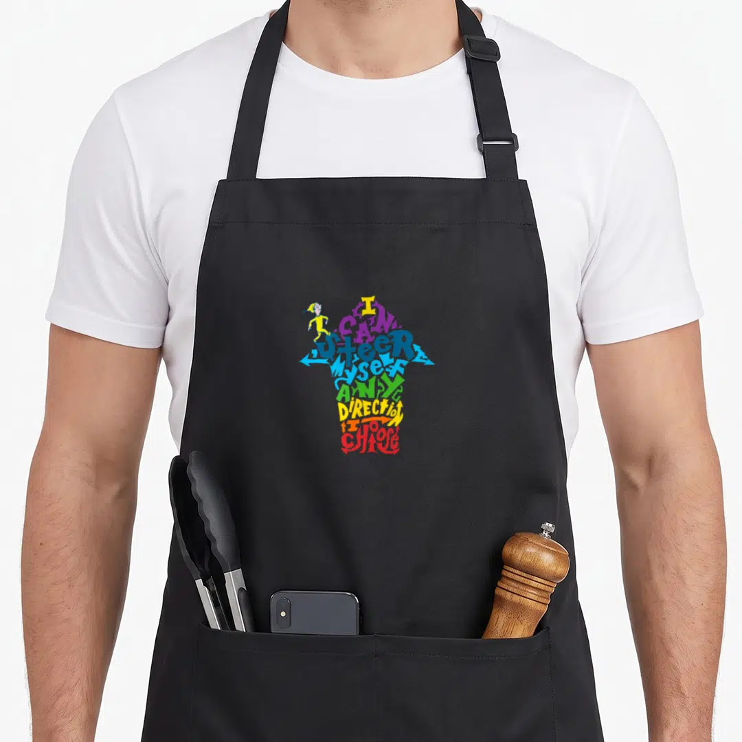 Youll general apron - Colorful text forming an upward arrow with a small running cartoon person on the left side — shown on a black cotton canvas apron against a white background