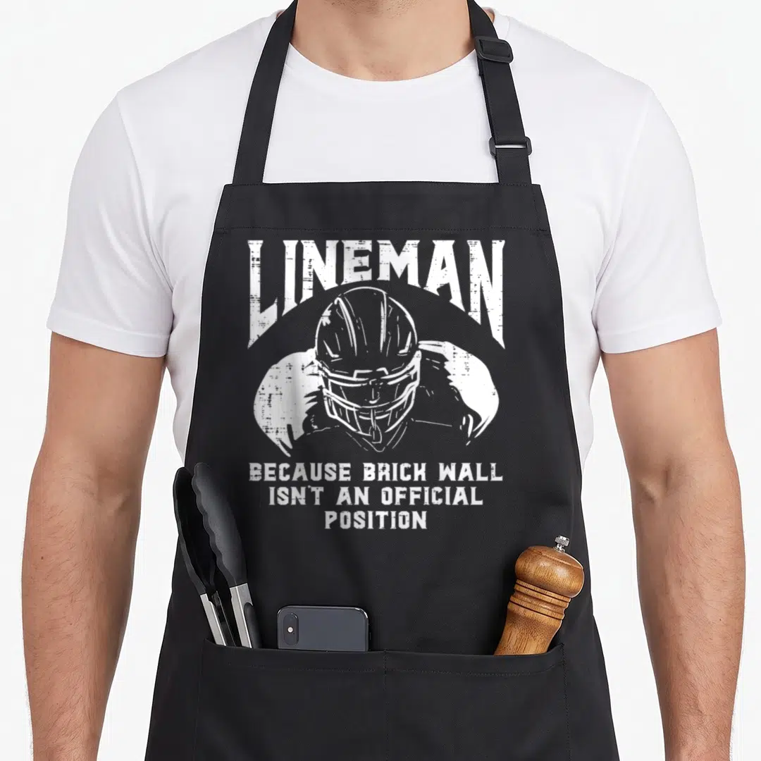 Brick football apron - White distressed lineman helmet graphic with sarcastic quote text — shown on a black cotton canvas apron against a white background