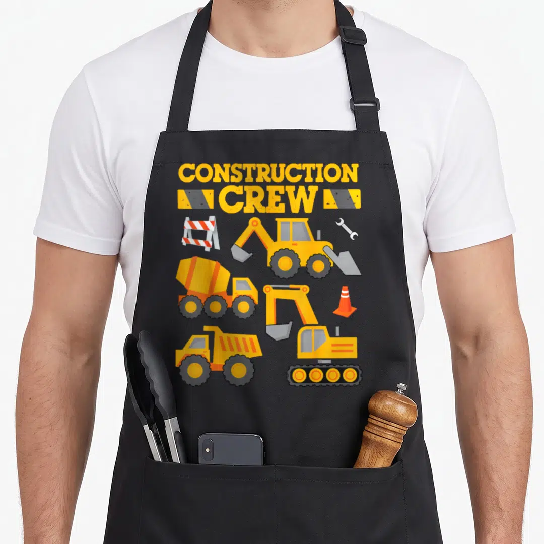 Crew construction worker apron - Cartoon excavator, cement mixer, and dump truck with CONSTRUCTION CREW text — shown on a black cotton canvas apron against a white background