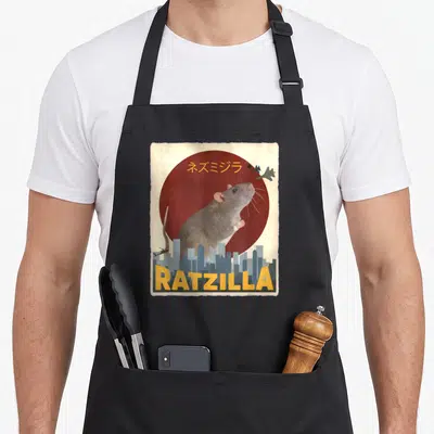 Veterinarian anime apron - Giant grey rat behind city skyline under red sun with yellow RATZILLA text — shown on a black cotton canvas apron against a white background