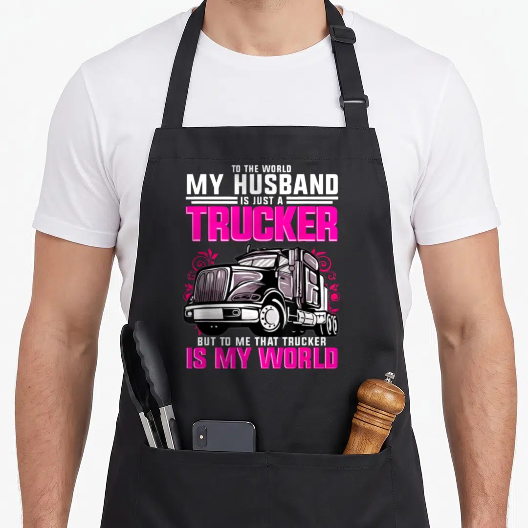 Trucker wife truck apron - Stacked text about a trucker husband above and below a grey truck with pink swirls — shown on a black cotton canvas apron against a white background