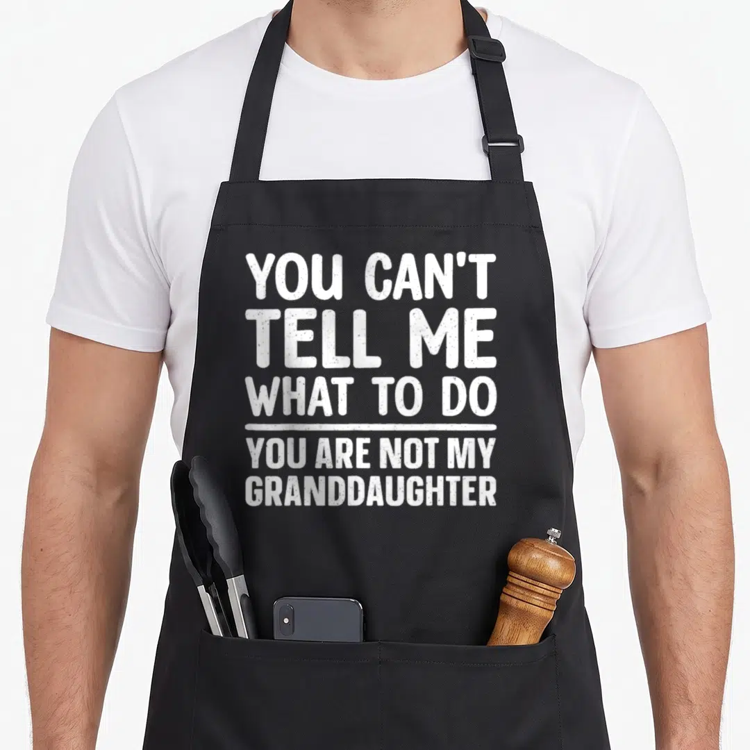 Papi grandpa apron - White stacked text reading You Can't Tell Me What To Do You Are Not My Granddaughter — shown on a black cotton canvas apron against a white background