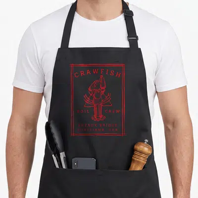 Crew cajun aprons - Red line art crawfish with Breaux Bridge Louisiana USA text enclosed in sketch border — shown on a black cotton canvas apron against a white background