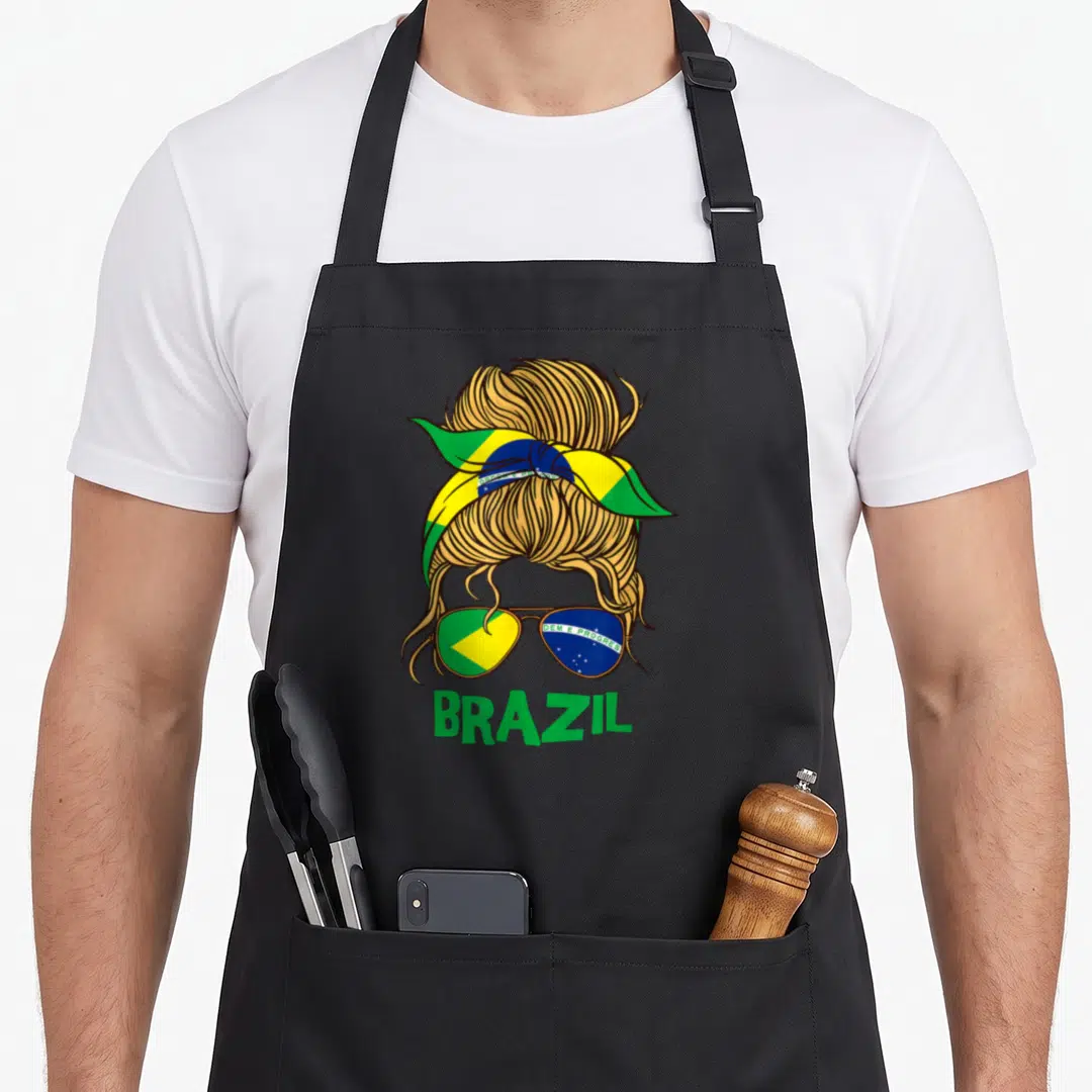 Brazil brazilian girl apron - Cartoon messy bun with Brazil flag headband, sunglasses showing DEM E PROGRES, and BRAZIL — shown on a black cotton canvas apron against a white background