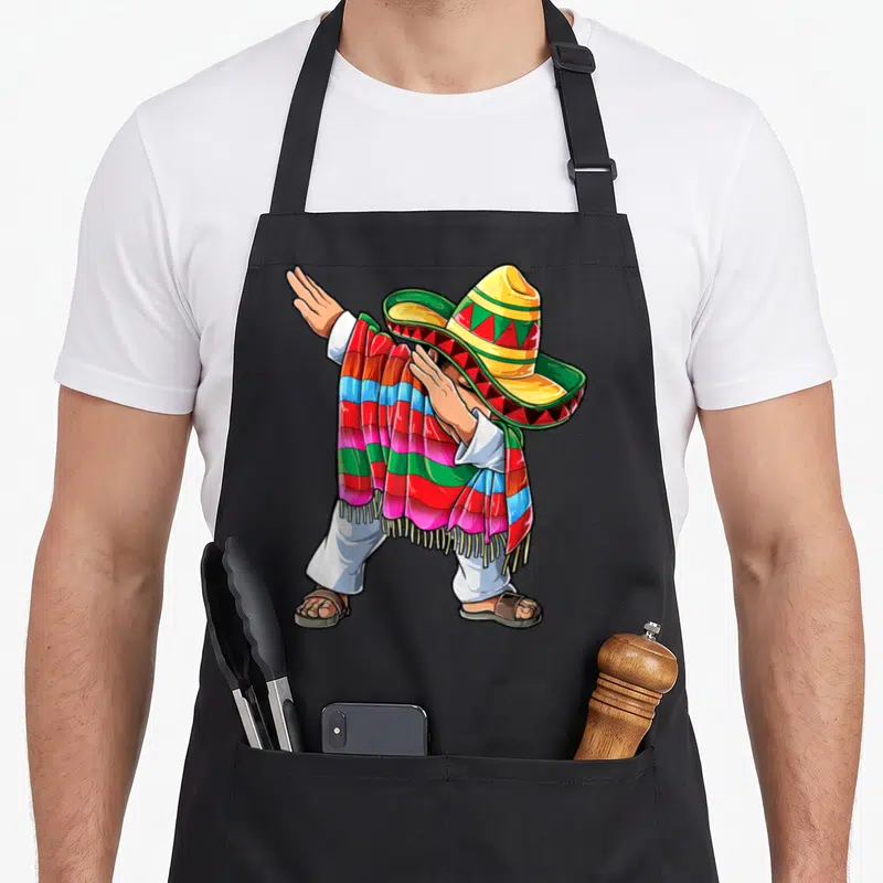 Dabbing mexican apron - Cartoon man in yellow sombrero and striped serape performing a dab dance pose — shown on a black cotton canvas apron against a white background