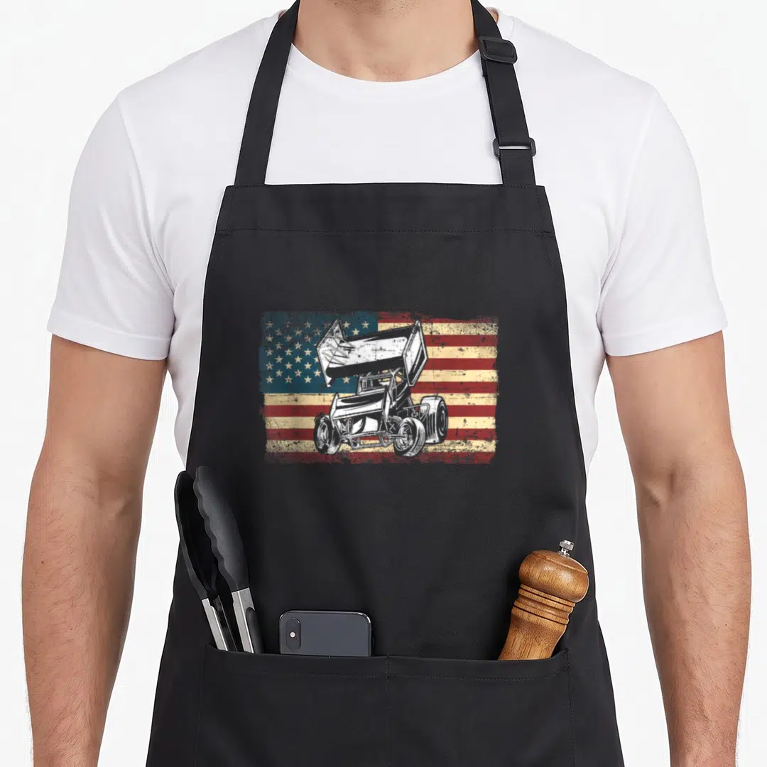 Racing sprint track apron - White sprint car over distressed red white and blue American flag graphic — shown on a black cotton canvas apron against a white background