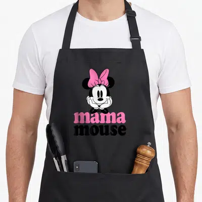 Mouse mama apron - Cartoon Minnie Mouse resting chin on hands above pink and black mama mouse text — shown on a black cotton canvas apron against a white background