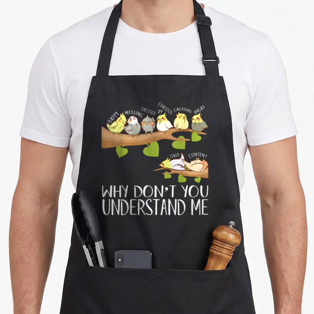 Emotion bird apron - Eight cartoon birds on branches labeled happy angry tired content with bottom text why dont you — shown on a black cotton canvas apron against a white background
