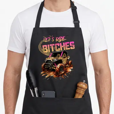 Four utv girl apron - Leopard print UTV in mud with pink and yellow text LET'S RIDE BITCHES — shown on a black cotton canvas apron against a white background