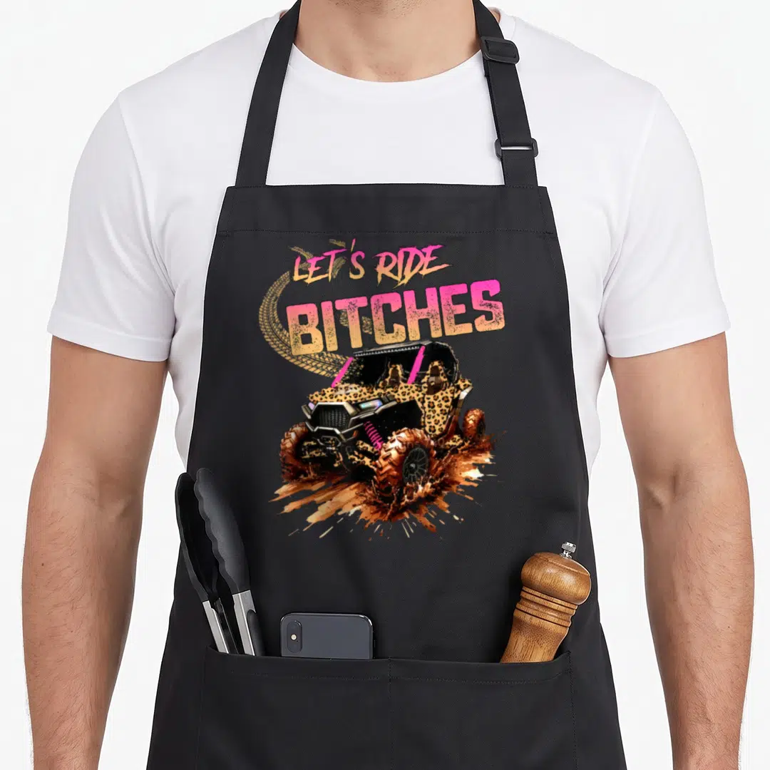 Four utv girl apron - Leopard print UTV in mud with pink and yellow text LET'S RIDE BITCHES — shown on a black cotton canvas apron against a white background