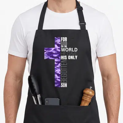 Christian camo apron - Purple camouflage cross with vertical white text FOR GOD SO LOVED THE WORLD HE GAVE HIS ONLY — shown on a black cotton canvas apron against a white background
