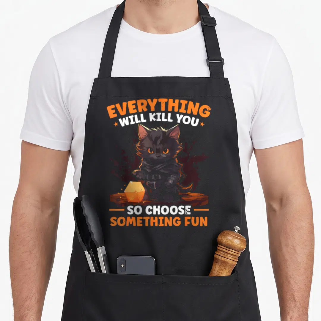Rpg role gaming apron - Cartoon black kitten holding orange d20 die with sarcastic gaming quote text — shown on a black cotton canvas apron against a white background