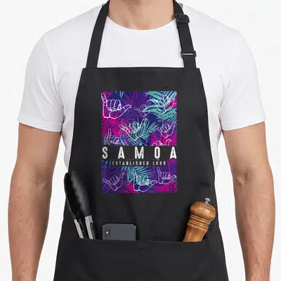 Samoan samoa apron - White shaka hands and palm leaves surrounding centered S A M O A text — shown on a black cotton canvas apron against a white background