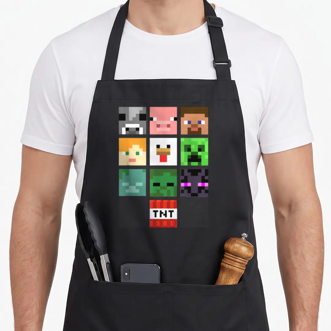 Shot face apron - Ten Minecraft pixel faces and TNT block on black bib apron — shown on a black cotton canvas apron against a white background