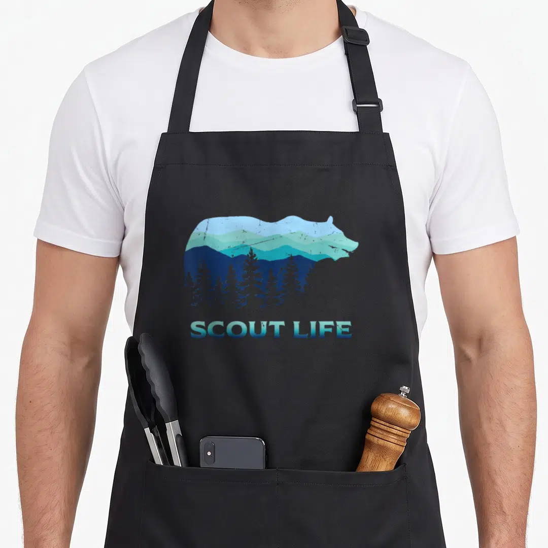 Scout camping apron - Bear silhouette containing blue mountains and pine trees with SCOUT LIFE text below — shown on a black cotton canvas apron against a white background