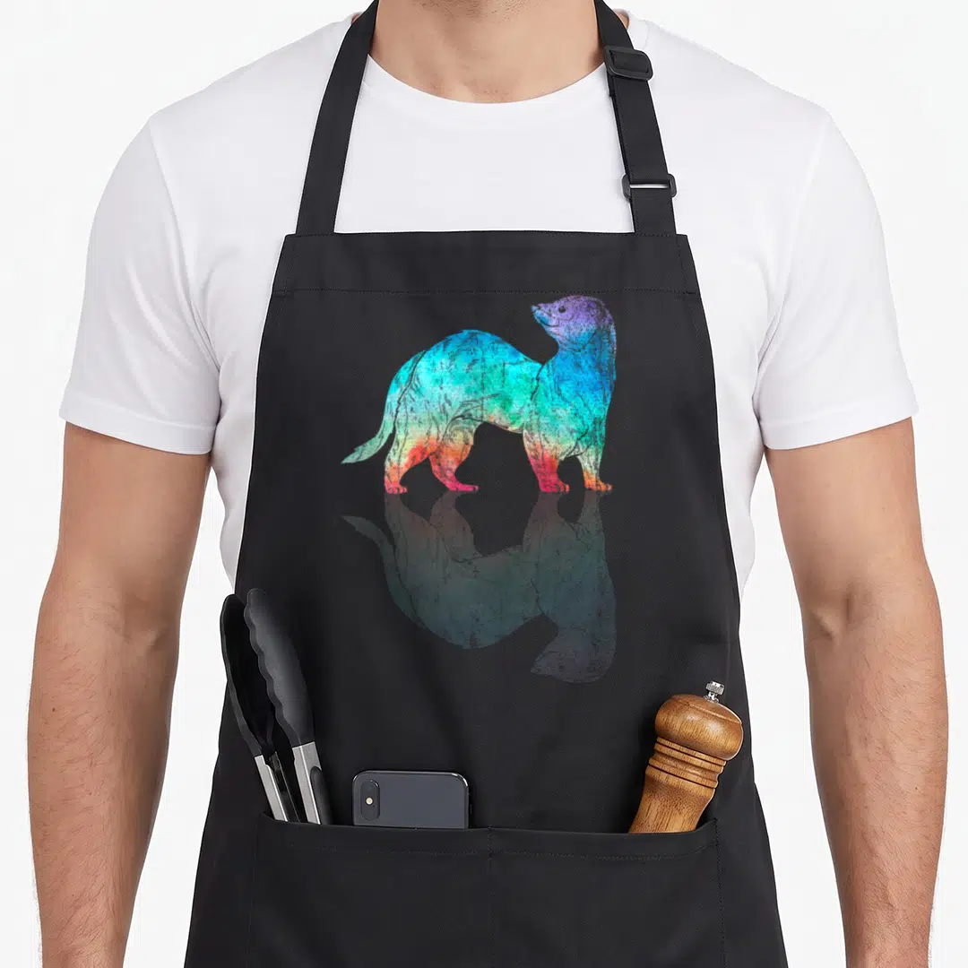 Pet colorful aprons - Rainbow watercolor otter silhouette with faded reflection in blue green yellow red purple — shown on a black cotton canvas apron against a white background