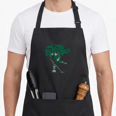 Mikko sports fan apron - Green and white line art of hockey player number 96 with arched text The Moose Is Loose — shown on a black cotton canvas apron against a white background