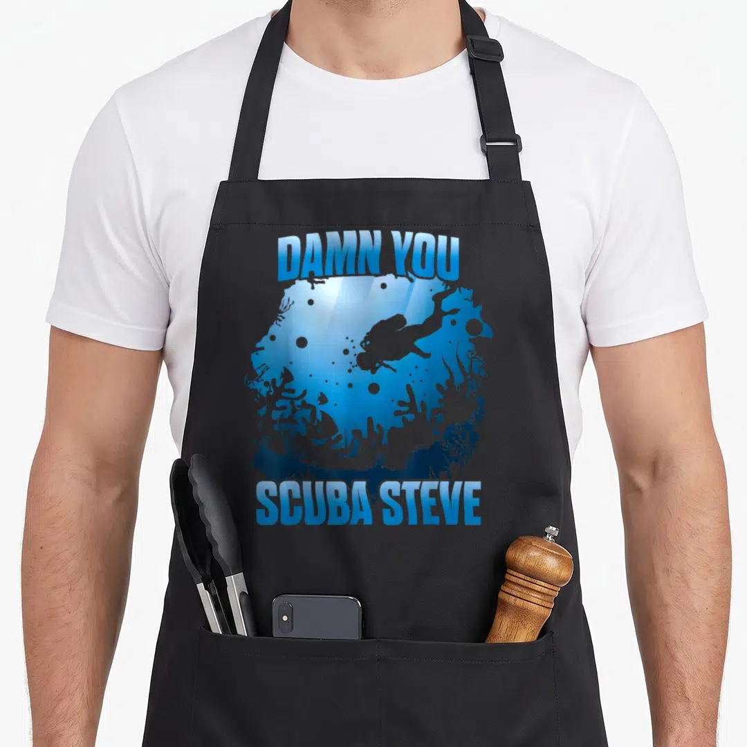 Scuba swimming apron - Arched DAMN YOU SCUBA STEVE text framing a blue diver and coral silhouette scene — shown on a black cotton canvas apron against a white background
