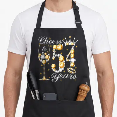 54th wine apron - Gold and white rhinestone style text Cheers to 54 years with glass crown and lips — shown on a black cotton canvas apron against a white background