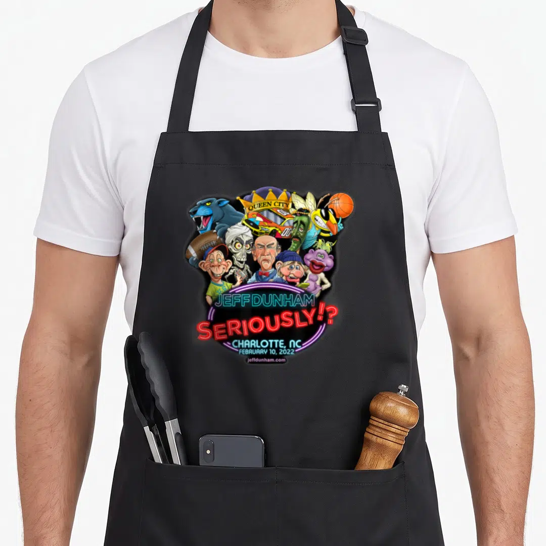 Jeff charlotte apron - Caricatures of Jeff Dunham puppets with neon SERIOUSLY text and Queen City crown logo — shown on a black cotton canvas apron against a white background