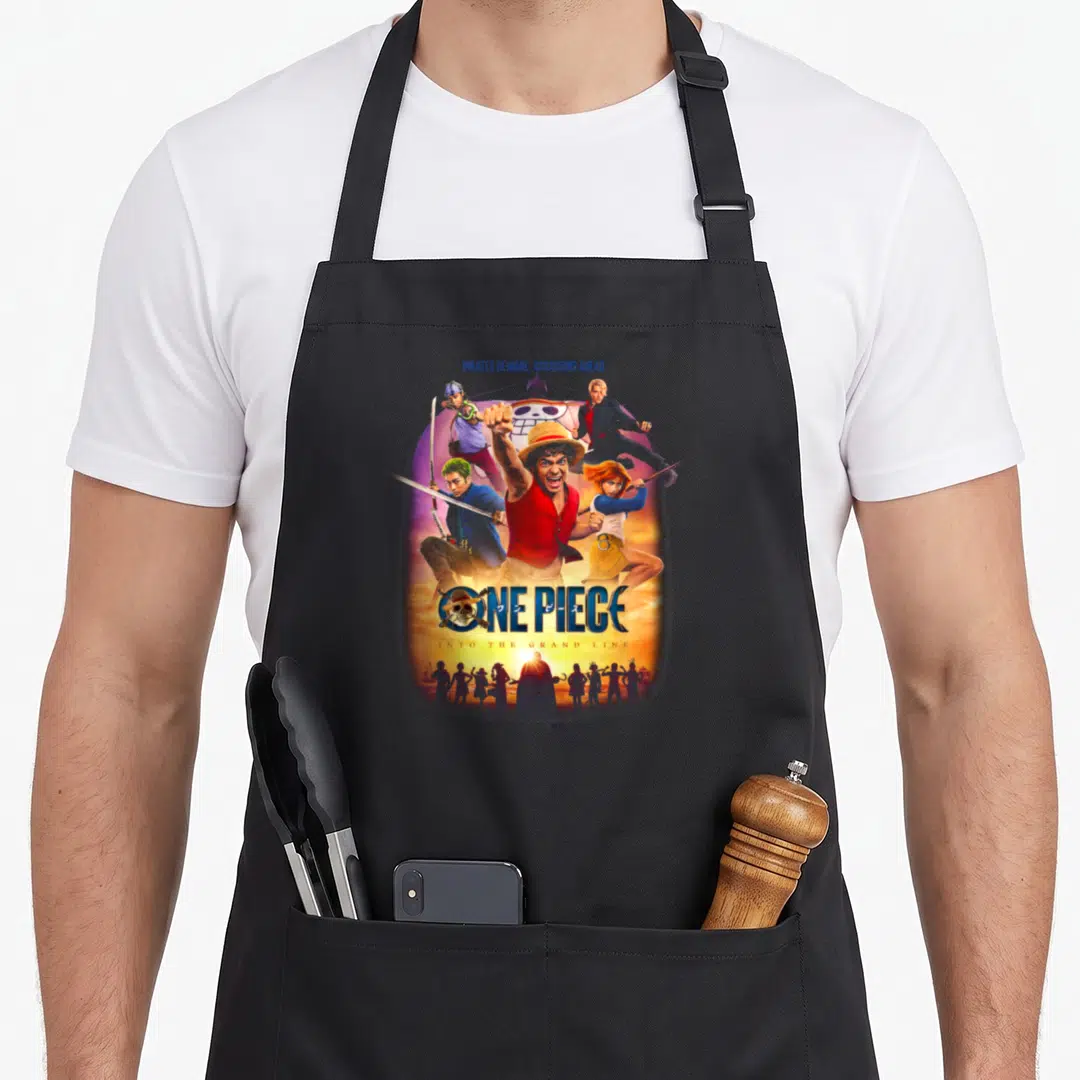 Beware novelty apron - One Piece characters Pirates Beware Assassins Ahead text cartoon art — shown on a black cotton canvas apron against a white background