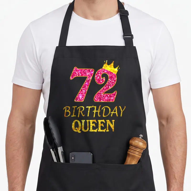 72nd queen apron - Pink glitter number 72 with gold crown and BIRTHDAY QUEEN text — shown on a black cotton canvas apron against a white background