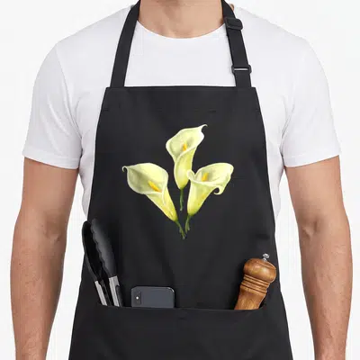 Calla white lily apron - Three realistic calla lilies in white yellow and green with stems meeting at bottom — shown on a black cotton canvas apron against a white background