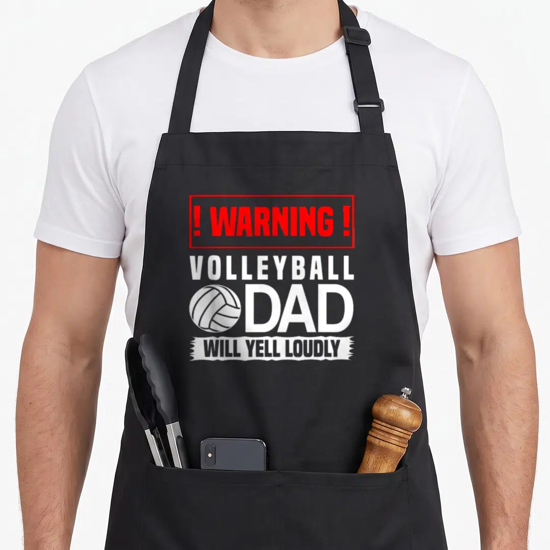 Volleyball dad mode apron - Red warning box and white volleyball graphic with text yelling loudly — shown on a black cotton canvas apron against a white background