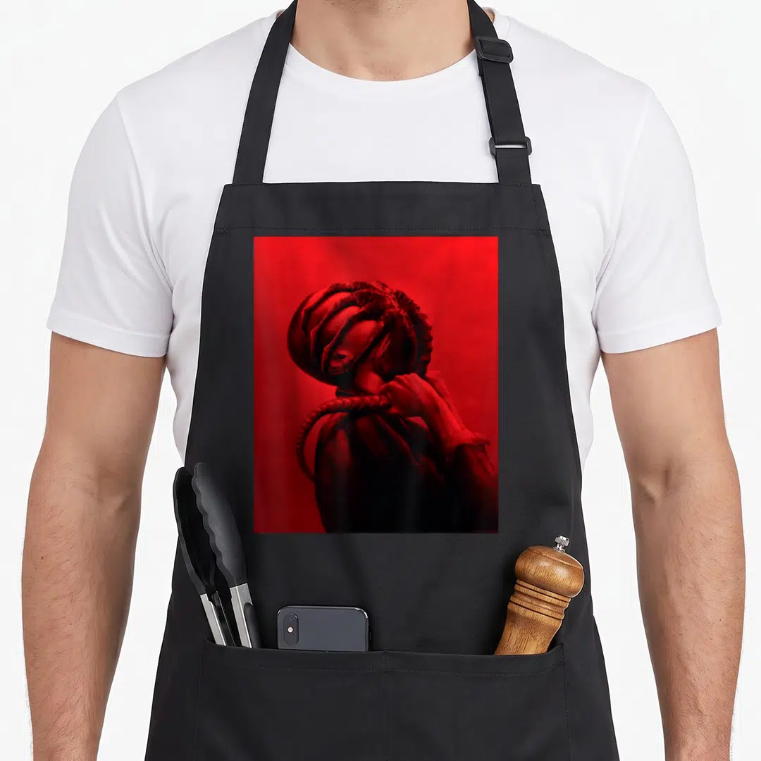 Romulus 20th century studios apron - Realistic red and black illustration of a person with tentacles wrapping around — shown on a black cotton canvas apron against a white background