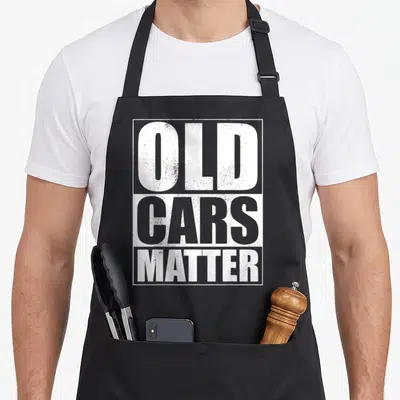 Matter enthusiast car apron - Stacked white and grey text reading OLD CARS MATTER inside a rectangular border — shown on a black cotton canvas apron against a white background