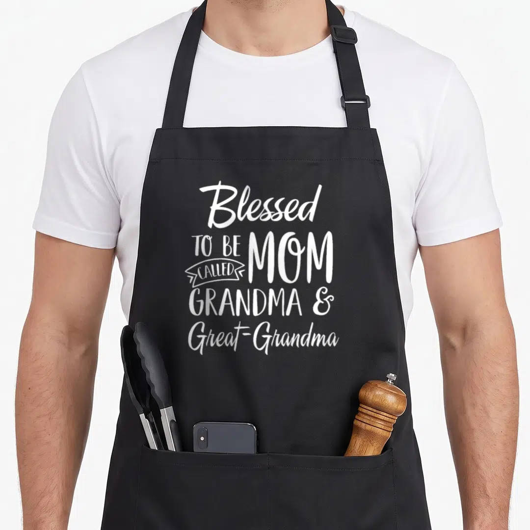 Called mother's day aprons - White stacked text reading Blessed to be called Mom Grandma Great-Grandma on black fabric — shown on a black cotton canvas apron against a white background