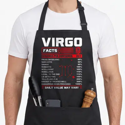 Fact birthday apron - Virgo nutrition facts label design with red constellation and trait percentages — shown on a black cotton canvas apron against a white background