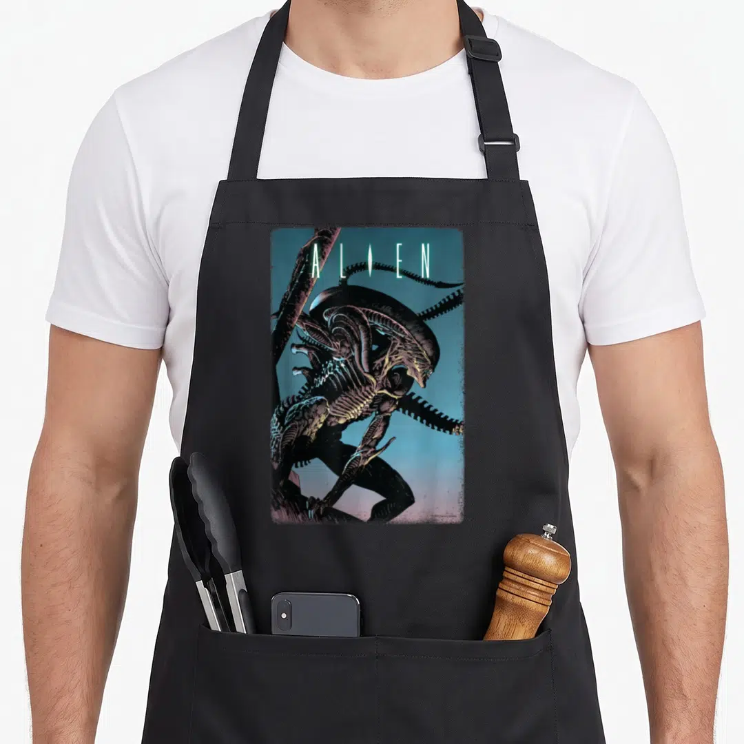 Alien 20th century studios apron - Realistic Xenomorph illustration with ALIEN text in black blue purple and yellow — shown on a black cotton canvas apron against a white background