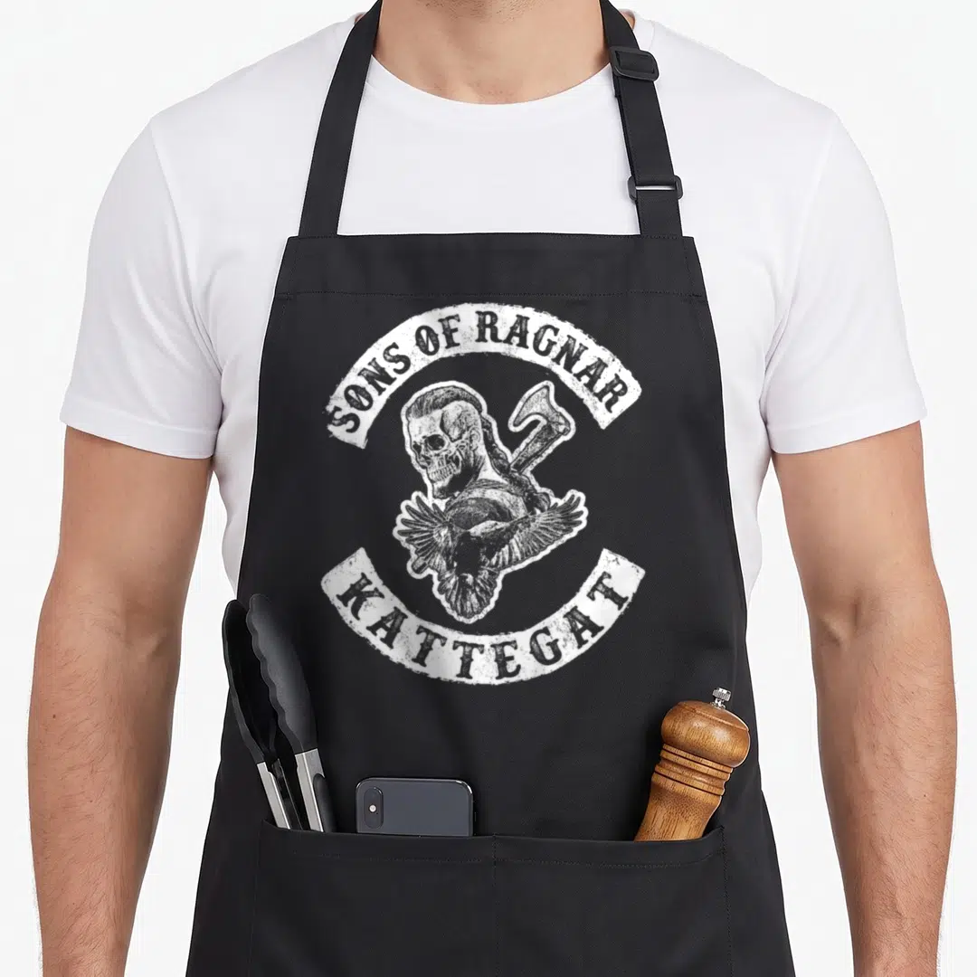 Ragnar dad and son aprons - White distressed skull axe and raven surrounded by Sons of Ragnar Kattegat text banners — shown on a black cotton canvas apron against a white background