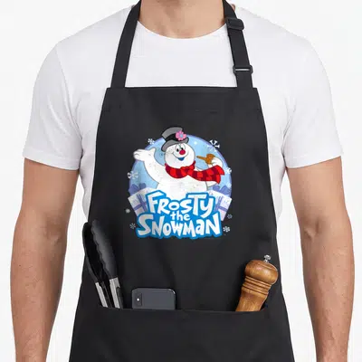 Funny frosty snowman apron - Waving cartoon snowman with red scarf and Frosty the Snowman text over two gift boxes — shown on a black cotton canvas apron against a white background