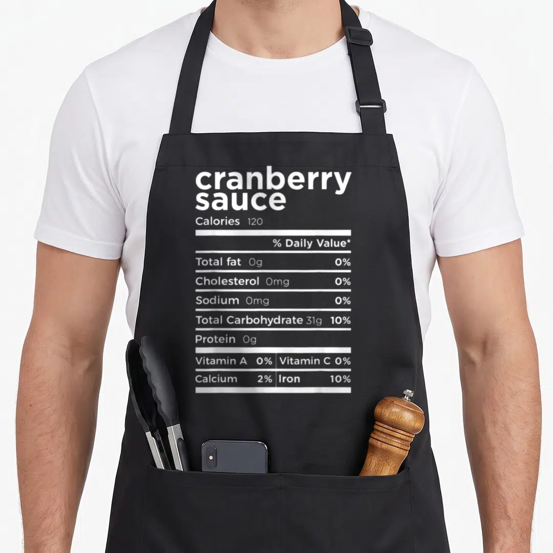 Sauce thanksgiving apron - White nutrition label typography listing zero fat and cholesterol for cranberry sauce — shown on a black cotton canvas apron against a white background