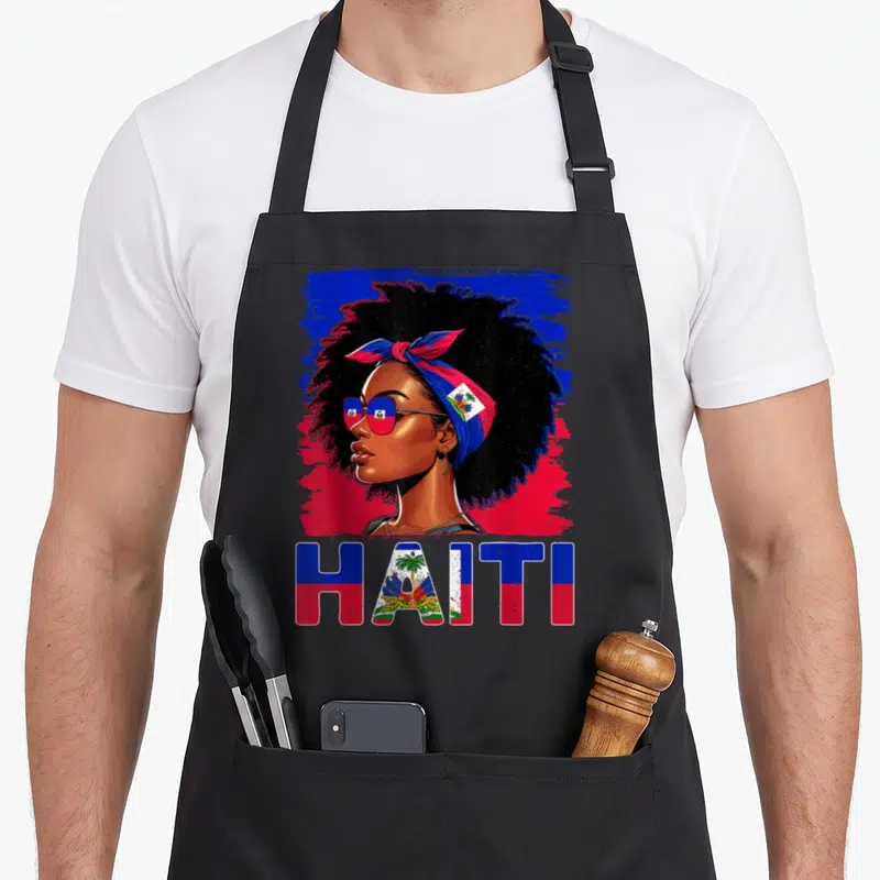 Haitienne haitian apron - Cartoon woman portrait with HAITI text filled in blue and red flag pattern — shown on a black cotton canvas apron against a white background