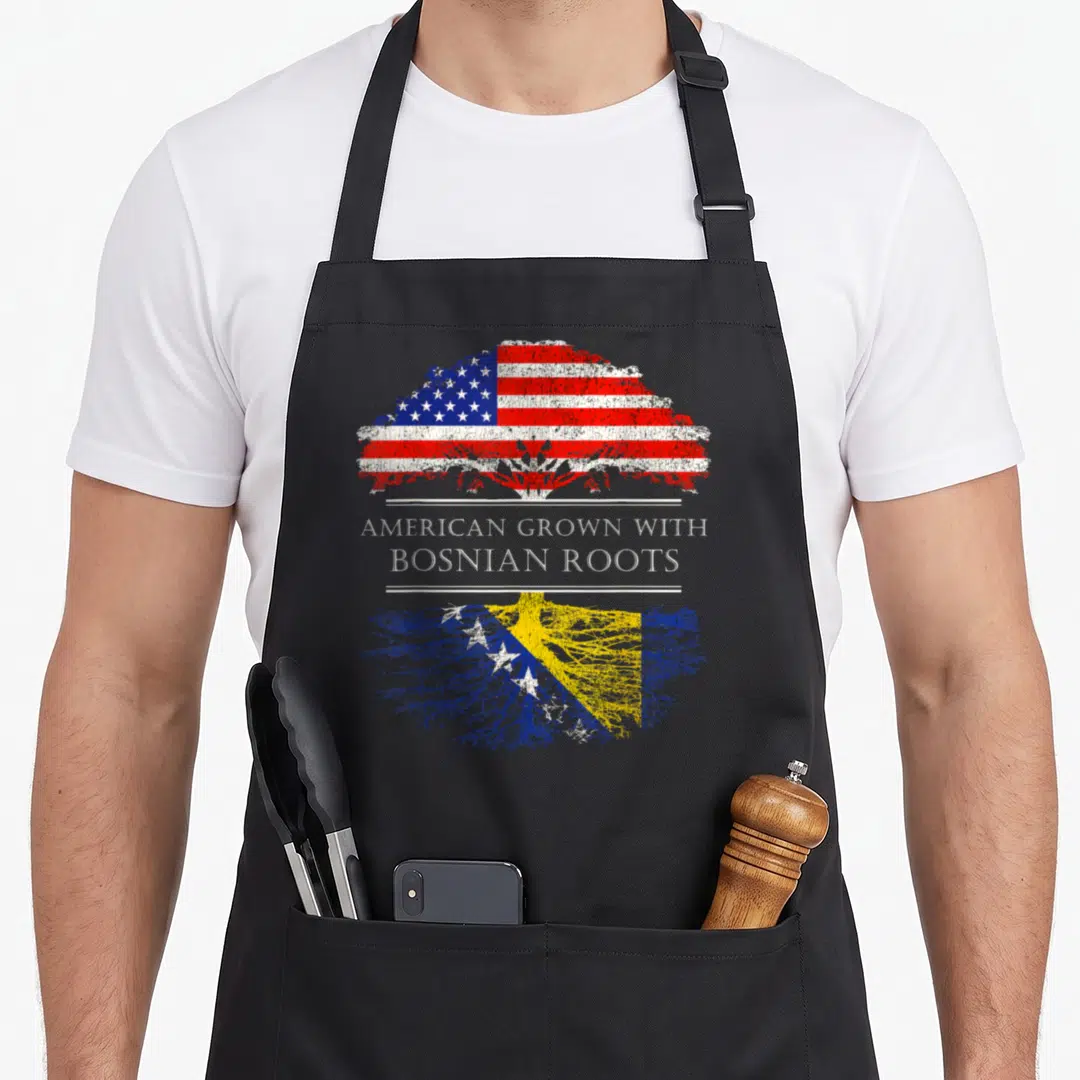 Root father day apron - Tree with US flag leaves and Bosnia flag roots and text American Grown With Bosnian Roots — shown on a black cotton canvas apron against a white background