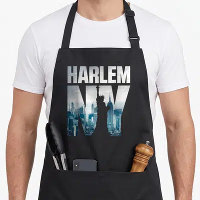 Harlem skyline new york apron - HARLEM NY text with photo skyline and statue silhouette in blue grey white — shown on a black cotton canvas apron against a white background