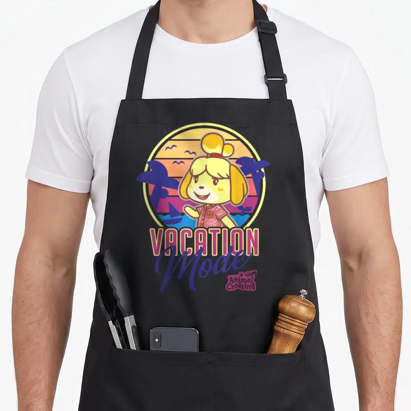 Horizon tongariro crossing apron - Isabelle character in circular sunset with palm trees, boat, birds, and VACATION — shown on a black cotton canvas apron against a white background