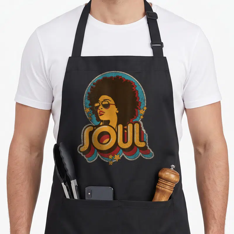 Funk afro soul 70s apron - Retro woman in blue circle with yellow SOUL text and stars — shown on a black cotton canvas apron against a white background