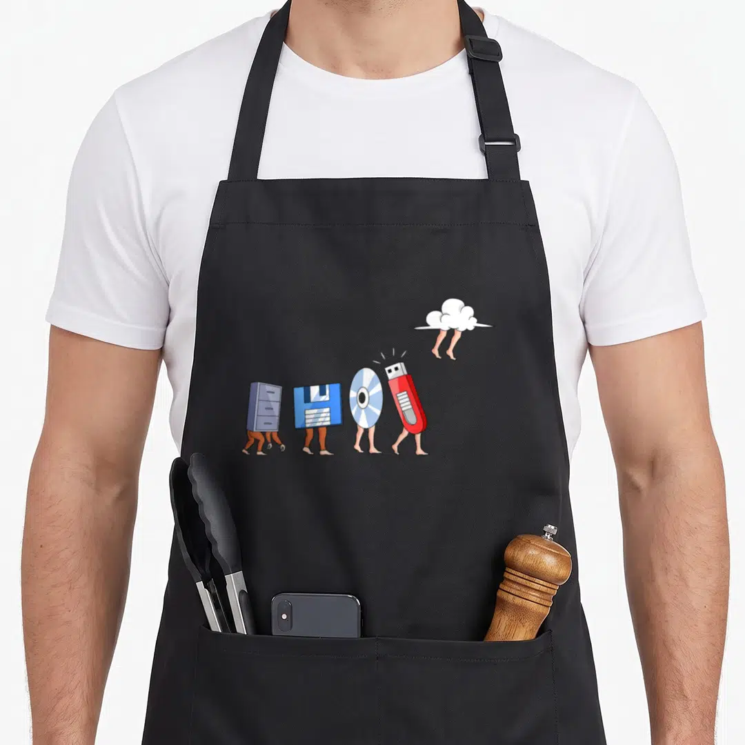 Geek nerd apron - Cartoon storage media characters with legs walking toward a cloud in blue red and silver — shown on a black cotton canvas apron against a white background