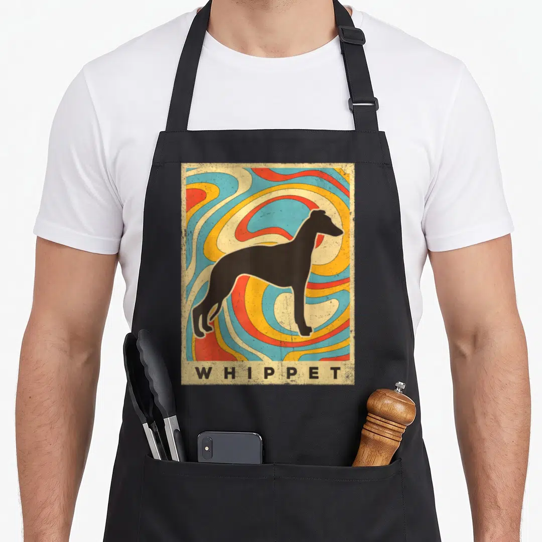 Cool whippet dog apron - Black whippet silhouette on colorful retro swirls with beige bar reading WHIPPET — shown on a black cotton canvas apron against a white background