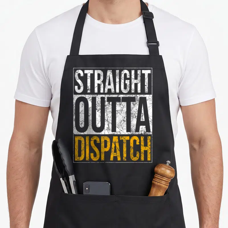 Straight dispatcher apron - Distressed stacked text STRAIGHT OUTTA DISPATCH in white and orange with white border — shown on a black cotton canvas apron against a white background