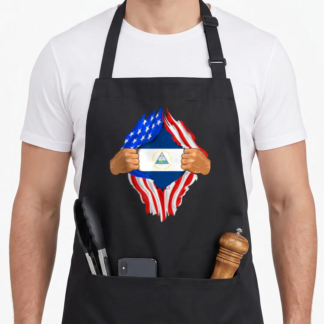 Nicaraguan blood apron - Hands tearing US flag to reveal Nicaragua flag with Republica de Nicaragua text — shown on a black cotton canvas apron against a white background