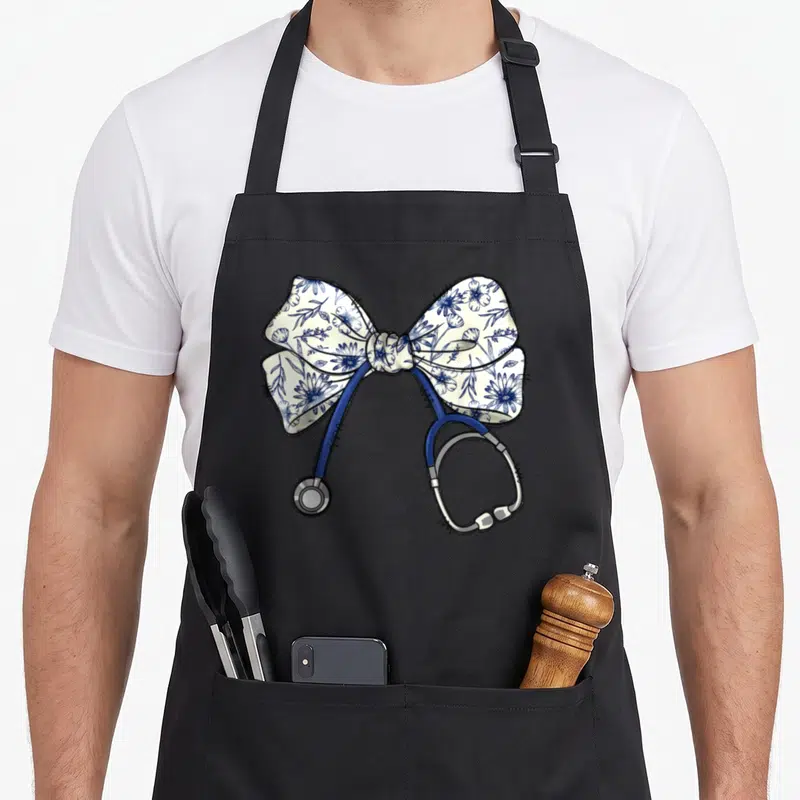 Blue floral apron - Cartoon stethoscope with blue tubing and silver parts wrapped in a white and blue floral coquette — shown on a black cotton canvas apron against a white background
