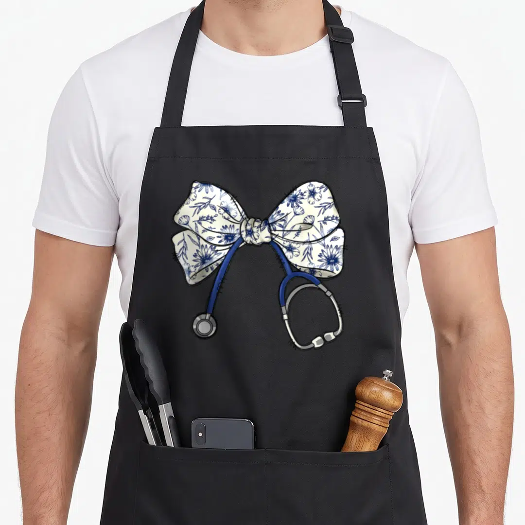 Blue floral apron - Cartoon stethoscope with blue tubing and silver parts wrapped in a white and blue floral coquette — shown on a black cotton canvas apron against a white background
