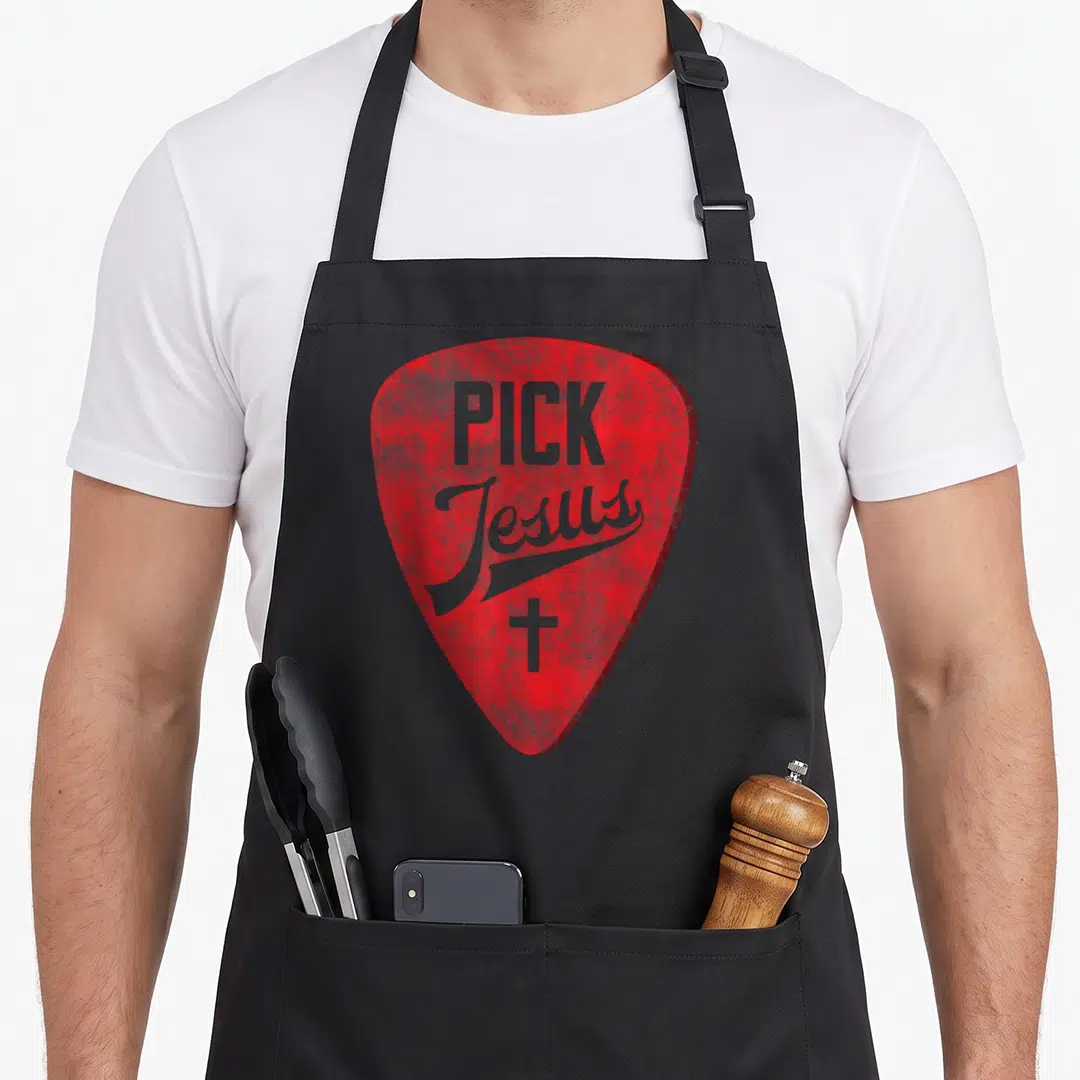 Pick jesus christian apron - Red guitar pick shape with distressed grey PICK Jesus text and cross — shown on a black cotton canvas apron against a white background